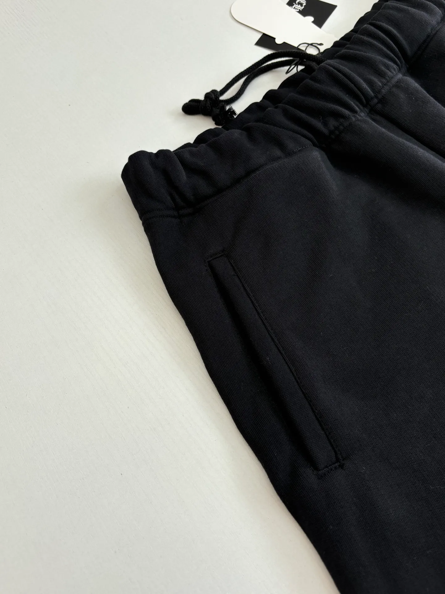 P346 Chrome Hearts*/Chrome Hearts 26SS early spring new patch embroidered shorts The fabric is made of a blended ratio of 80% cotton and 20% polyester. It is woven with a siro spinning process of 32-count base yarn and 10-count veil to form a high-weight terry cloth base of 380g/㎡. The cotton-polyester blended material combines the skin-friendly breathability of cotton and the anti-wrinkle shape retention of polyester. The high-weight fabric gives the trousers excellent stiffness and drape. The core technology is patch embroidery, which is completed with the help of TAJIMA computer embroidery machine. The black special-shaped patch is precisely sewn to the trouser fabric through lock stitches. The embroidery stitch density is even and the edges are neatly hemmed, forming a three-dimensional relief-like visual effect. Size: S/M/L/XL